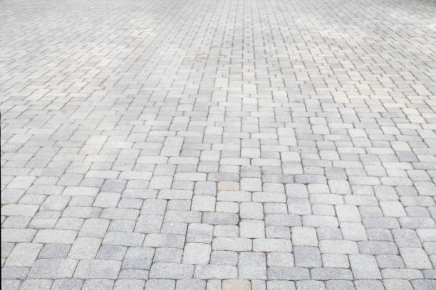 istock light grey brick road or driveway in one point perspective road side view 1428421514