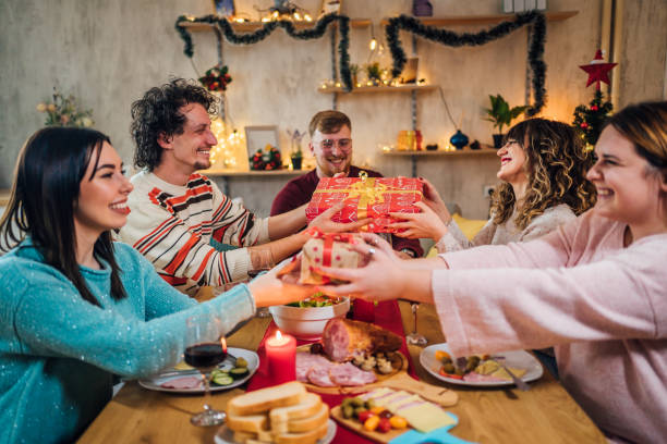 istock Friends exchanging Christmas gifts at dinner 1428422574