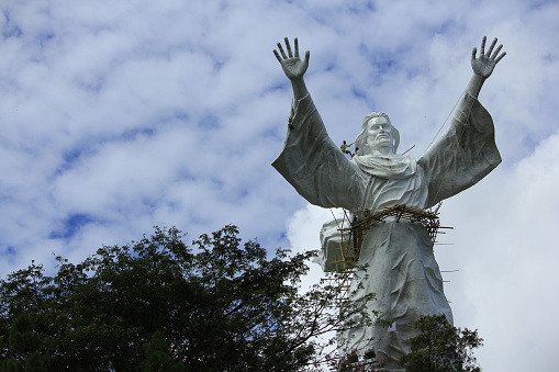 Manado, Indonesia, June 17, 2015. Workers take care of one of Manado's popular landmarks, the giant Jesus Blessing statue.