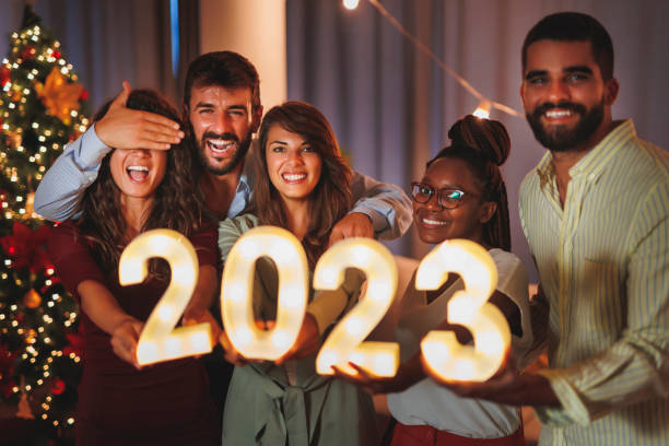 istock Friends holding illuminative numbers 2023 while celebrating New Year 1428424717