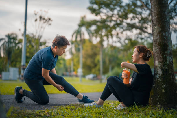 istock Disable Asian Chinese woman with deformed arm amputee resting sitting on ground talking with friend in public park daily evening exercise routine 1428424937