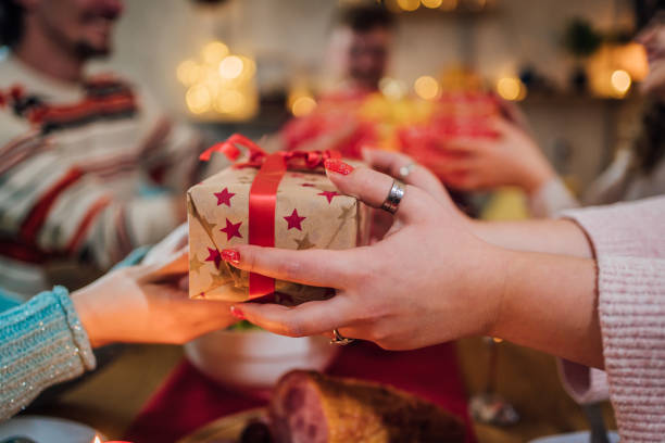istock Friends exchanging Christmas gifts at dinner 1428425994