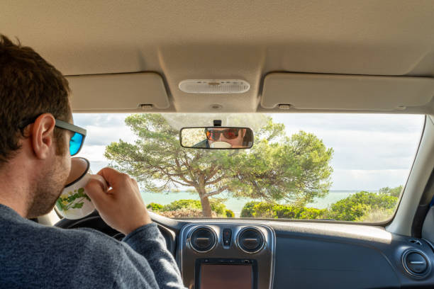 istock Young attractive male driver drinking a cup of coffee inside his camper van while is looking at the Mediterranean coastline. 1428430202