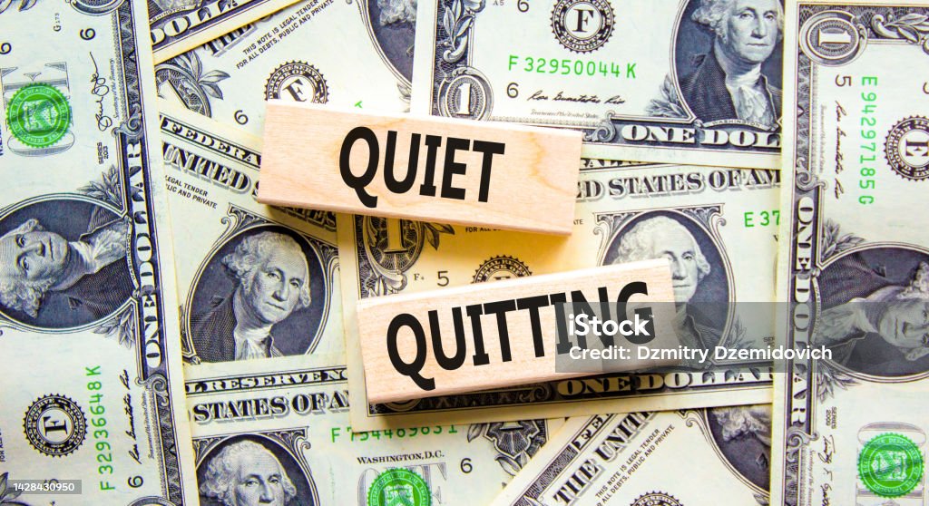 Quiet quitting symbol. Concept words Quiet quitting on wooden blocks. Beautiful background from dollar bills. Business and quiet quitting concept. Copy space. Quitting a Job Stock Photo