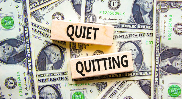 Quiet quitting symbol. Concept words Quiet quitting on wooden blocks. Beautiful background from dollar bills. Business and quiet quitting concept. Copy space. stock photo