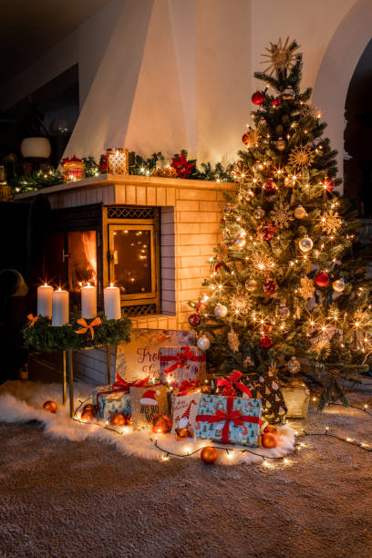 albero di natale con regali avvolti in accogliente soggiorno con camino alla vigilia di natale - fireplace christmas candle holiday foto e immagini stock