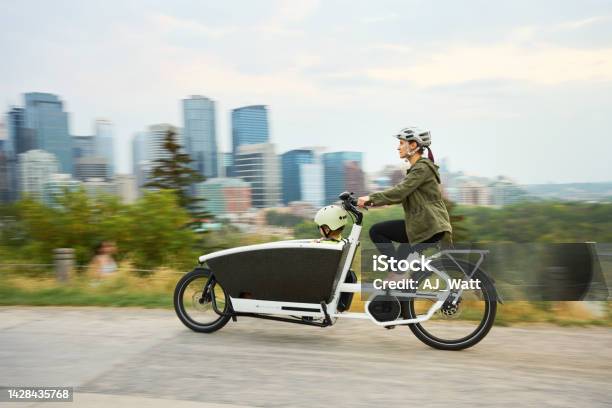 Mom And Riding A Cargo Bike With Her Young Son On A Park Path Stock Photo - Download Image Now