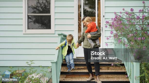 Mom And Her Little Sons Walking Down The Front Steps Of Their Home Stock Photo - Download Image Now