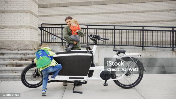 Mother And Little Sons Getting Off A Cargo Bike On A Sidewalk Stock Photo - Download Image Now
