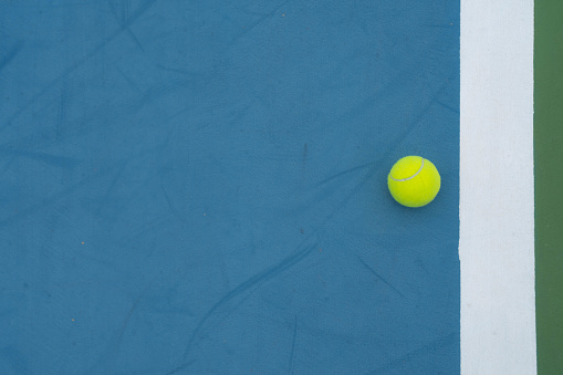Tennis court Top view Six tennis balls and racket on the green grass background. High quality photo