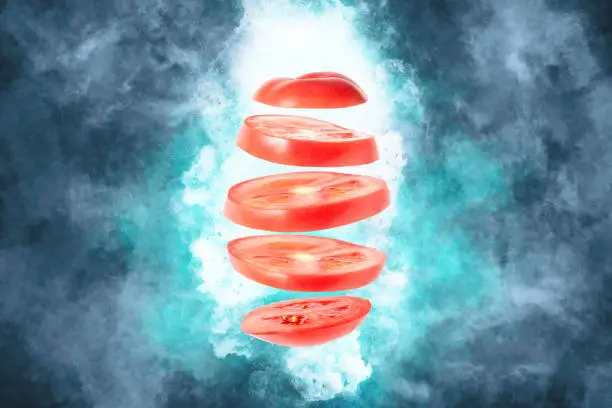 Levitation of tomato slices - tomato slices hang in the air on an abstract background