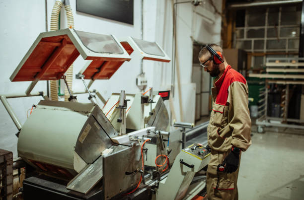 istock Employee in factory, using automated wood cutter 1428444159