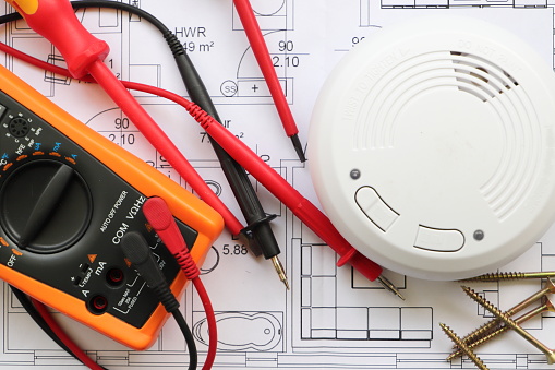 Smoke detectors are installed, he lies on the wiring diagram with a screwdriver and a meter