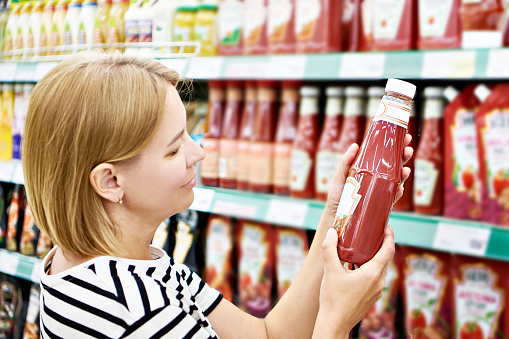 Packing of tomato ketchup in hands woman