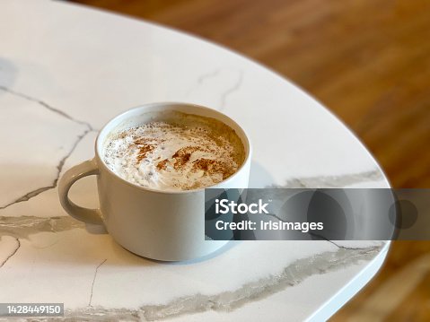 istock Pumpkin spice latte hot fall coffee and espresso drink in cup with whipped cream and spices on marble table and wood background with copy space 1428449150