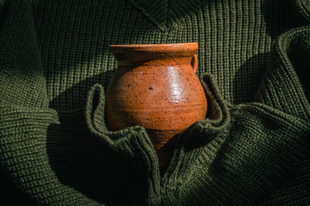 Knitted army green sweater holding a ceramic cup stock photo