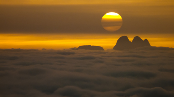 Sunset at the top of the mountain with silhouette of peaks and carpet of cloud, city of Teresopolis, state of Rio de Janeiro, Brazil