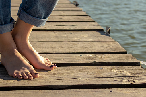 barefoot woman walking on the beach pier