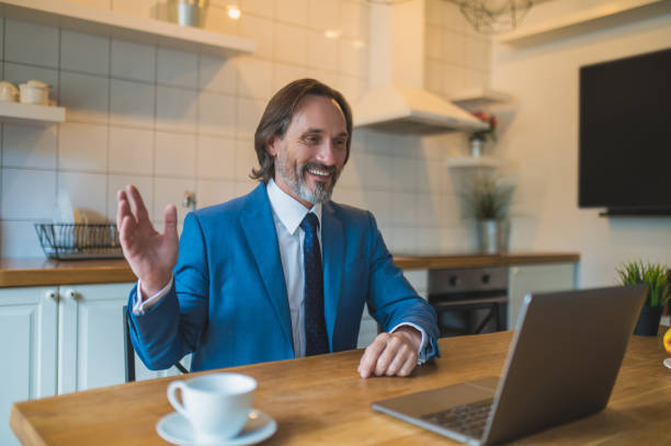 istock Man in blue suit having a vieo call and looking contented 1428462683