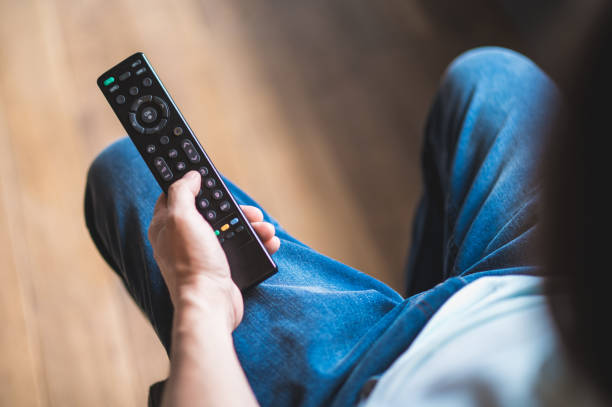 istock Man spending time at home and swithcing on tve with a tv remote 1428462736