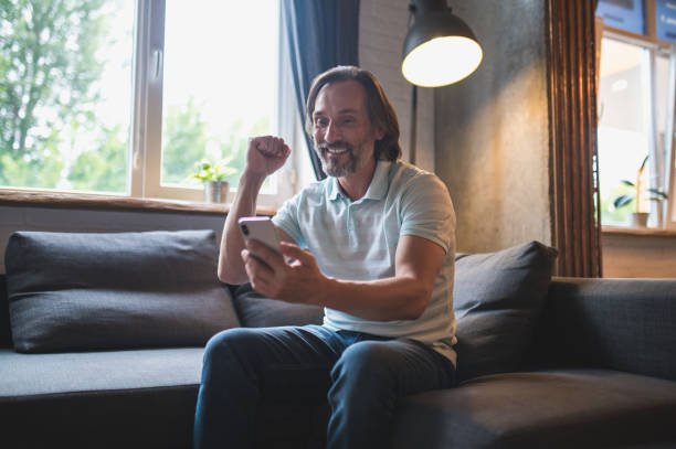 istock Mature man spending time at home and watching something on his smartphone 1428462792