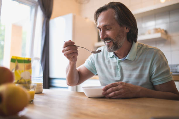 istock Mature caucasian man sitting at the table and eating breakfast 1428462846