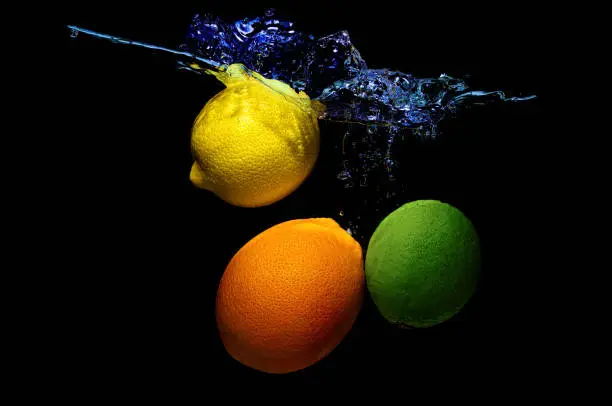 Photo of Citrus fruits dropped in water with splashes