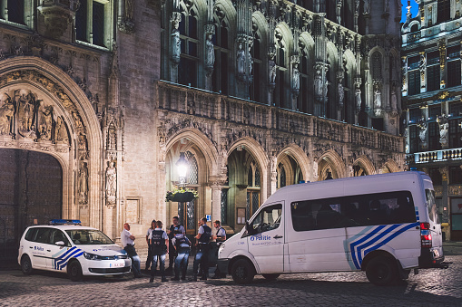 City of Brussels, Belgium - June 2021: The Belgian Federal Police (Dutch: Federale Politie; French: Police Fédérale) officers with car at the Grand Place square in front of the Town Hall
