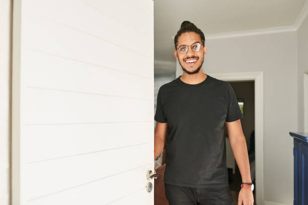 istock Young man opening the front door and smiling 1428476728
