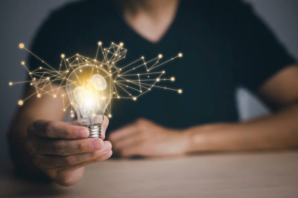 istock Businessman hand holding light bulb with icons and working on the desk, Creativity and innovation are keys to success.Concept of new idea and innovation with energy and power , working at home, 1428485607