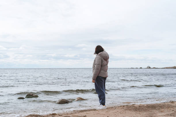 istock Woman from the back on the beach in cold weather 1428496265
