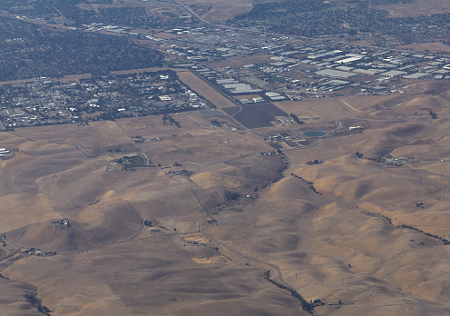 Mostly Clear Brown Hills Giving Way To Community And Roads Aerial Image