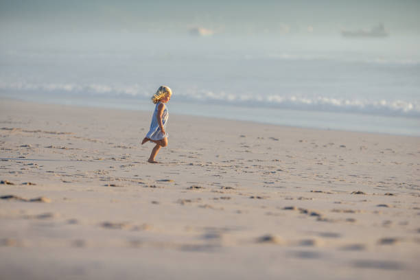 istock Little girl running barefoot on a sandy West Cape beach 1428508303