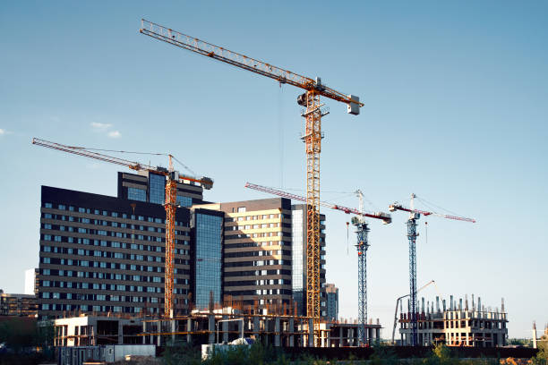 siluette di gru a torre e grattacieli - crane construction construction site built structure foto e immagini stock