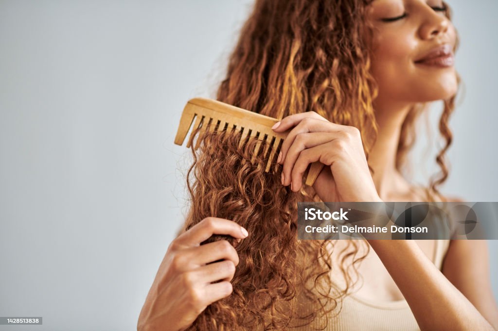 Hair Care Beauty And Woman Brushing Her Curly Hair With A Wooden Comb  During Her Self Care Routine Beautiful Young And Hispanic Girl Combing Her  Clean Natural Locks In A Studio With