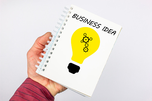 The business idea concept. A businessman holds a notebook with a creative image of a business idea, search, goal.