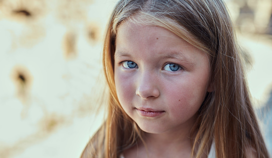 Portrait of cute baby girl with red cheeks and blue eyes.