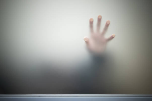istock Male hand behind gray blurred matte glass wall 1428525755