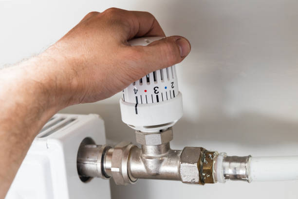 istock Male hand changes power of home radiator, close up 1428525760