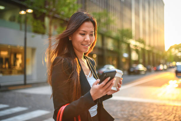 istock Young Korean Businesswoman Walking And Using A Smart Phone 1428526962
