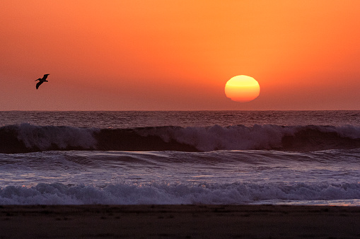 Sun setting over beach and waves, along a rural Pacific Ocean beach.\n\nTaken in Northern California, USA.