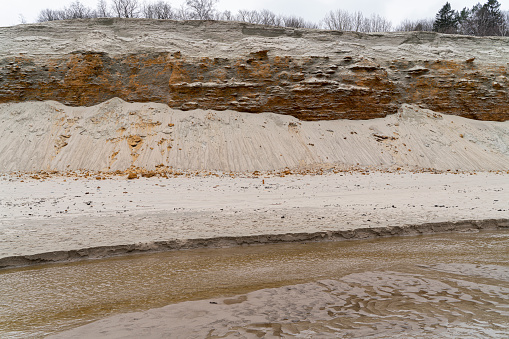 Baltic sea beach with big sand cliff in spring.