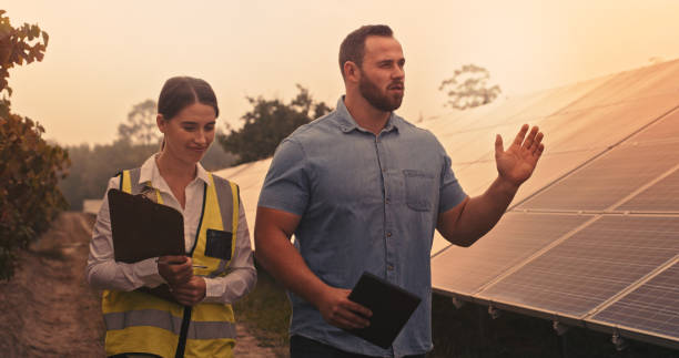 istock Solar energy engineering, contractor and manager planning roof construction, architecture and building development. Builder, electrician and workers sustainable project maintenance discussion on site 1428532212