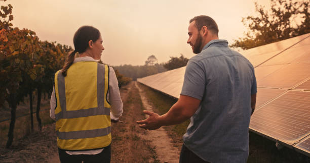 istock Solar panel, farm and people engineer for agriculture talking of power saving electricity, sustainability or renewable energy. B2B business woman working on carbon capture in sustainability industry 1428532218