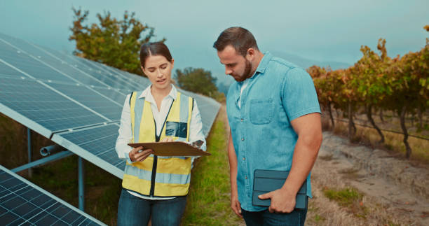 Wine farmer, vineyard and solar energy engineer woman  at renewable energy site planning checklist for solar panel electricity. Innovation and sustainability agriculture and engineering teamwork stock photo