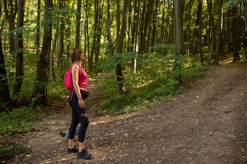 Woman enjoying her hike in the sunny woods