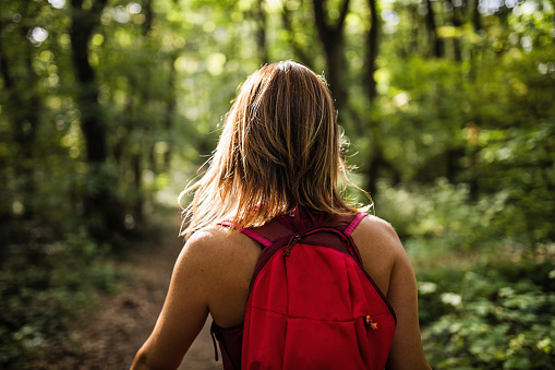 Rear view of a woman hiking with a backpack