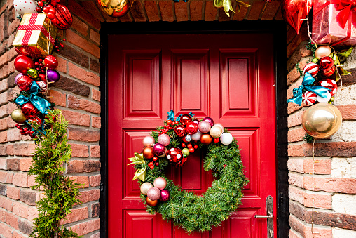 Waiting for Christmas - Red Wooden Front Door Decorated with Wreath, Garlands, Dwarfs, Gifts,...