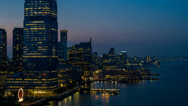 istock Jersey City panoramic view, along the Hudson River, illuminated in the evening. 1428540797