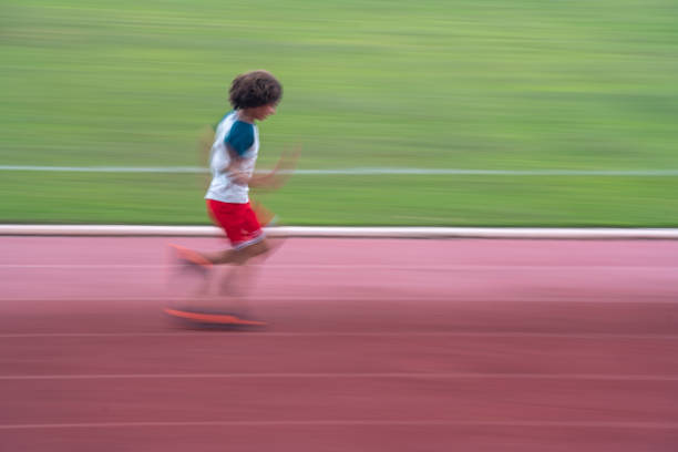 Beautiful athletic mid-adult woman stretching before running on a running track outdoors.